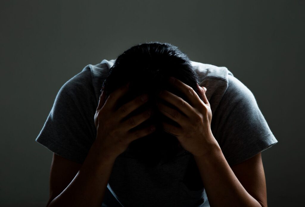 Sad and depressed man covering face